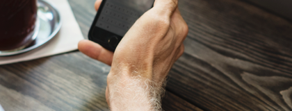 Business man looking at IT Security Services on his phone