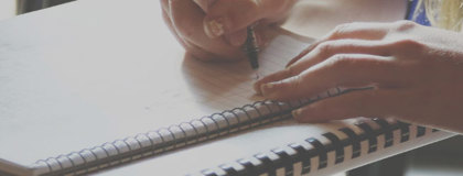 Woman writing notes on a note pad about IT Security