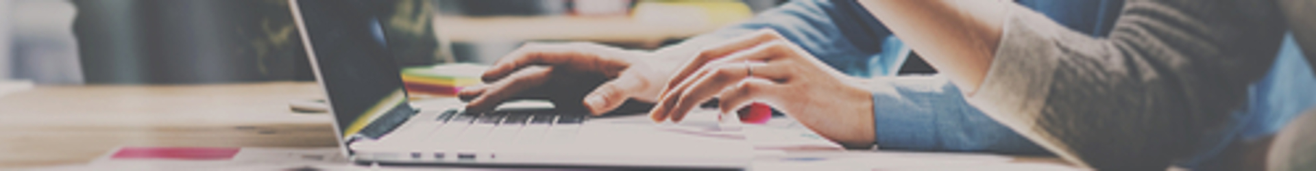 Decision makers looking at a laptop reviewing the benefits of the IT Policy Management as a Service