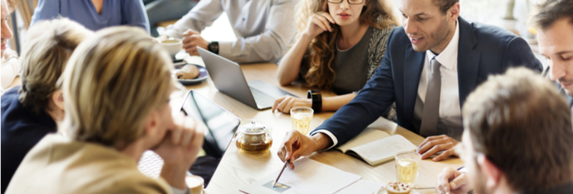 IT consultant going over IT Professional Services with a team of people sitting around a board room table