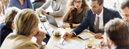 IT consultant going over IT Professional Services with a team of people sitting around a board room table 