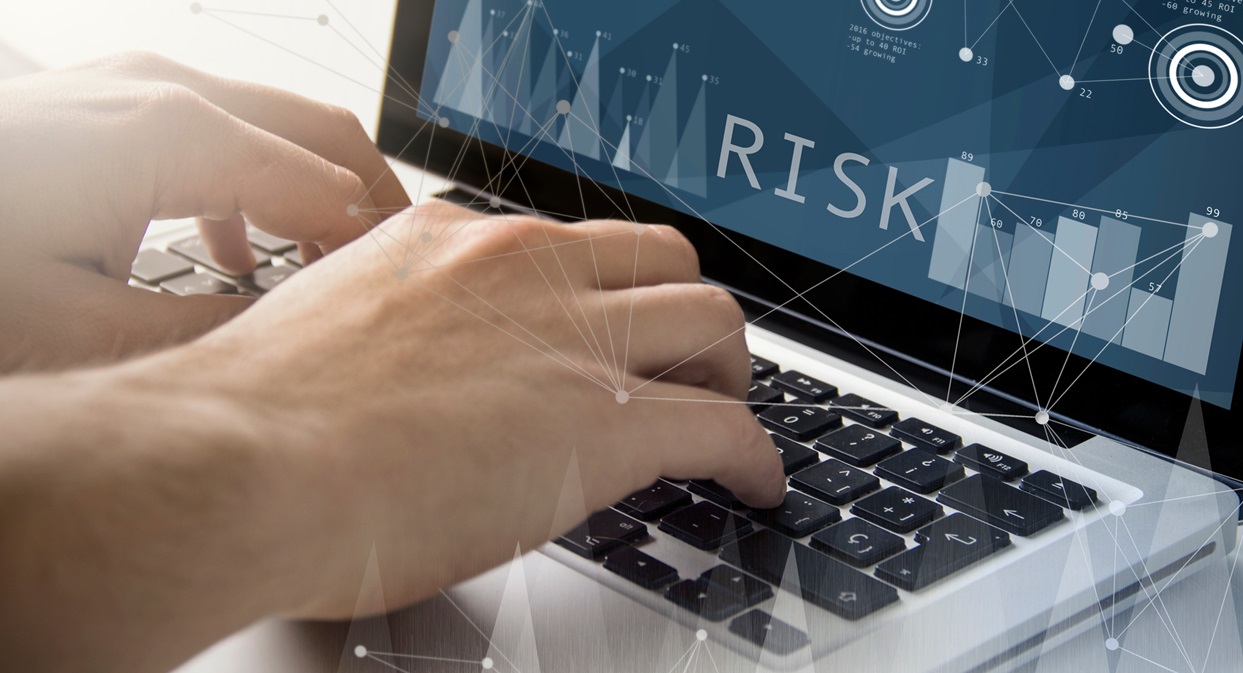 Close up of an Information security managers hands typing on a laptop establishing structured risk management practices