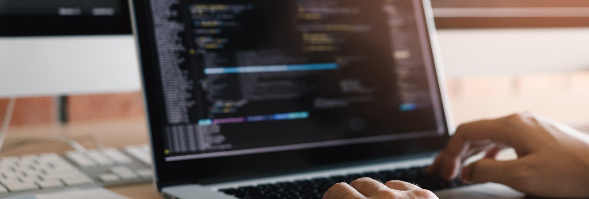 A close up a persons hands typing on a laptop updating their firewall rules