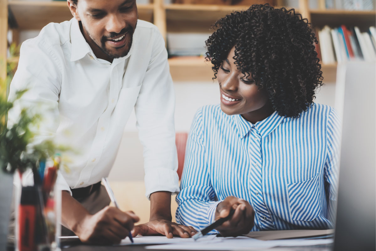 Two professionals reviewing documents and assessment information during a cyber security maturity review.