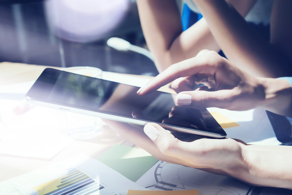 Woman using an iPad going through the IT Policy Management as a Service