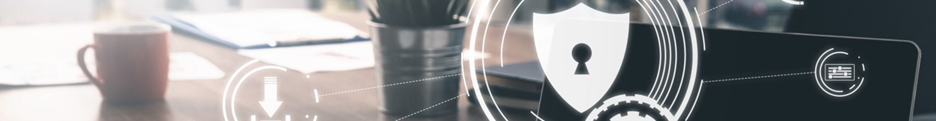 A laptop on a boardroom table with a holographic of an IT security shield leading to secured IT systems from a successful cybersecurity strategy