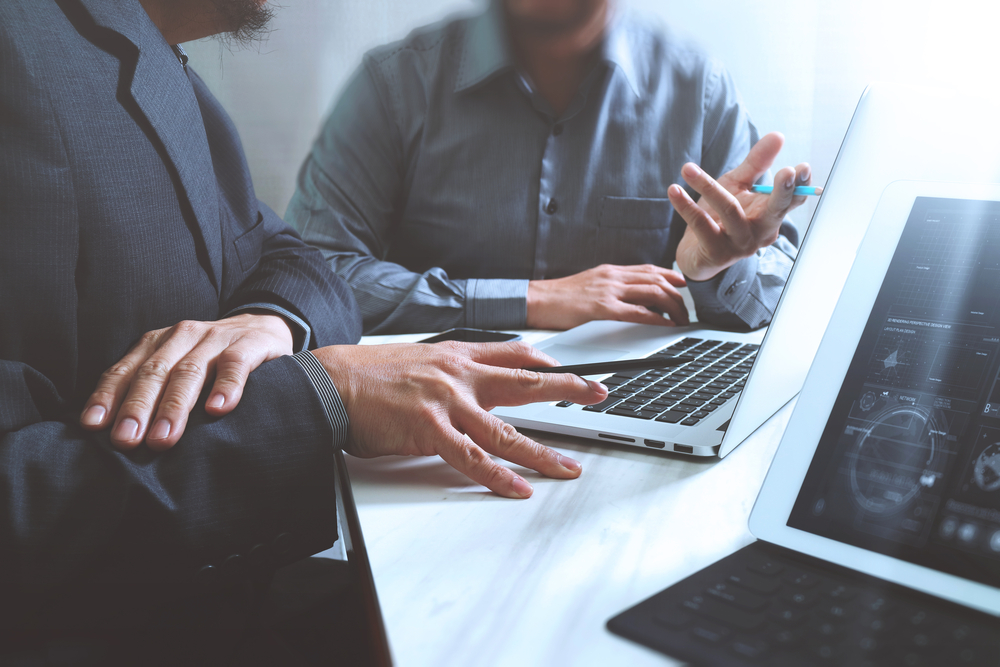 Professionals sitting in front of a laptop conducting a Third Party Information Security Risk Review